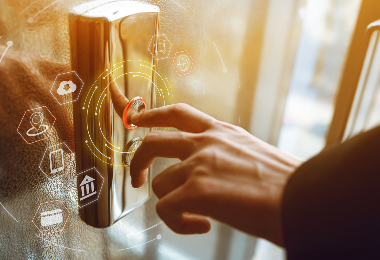 elevator code compliance — Close-up of a man's hand pressing the elevator button.